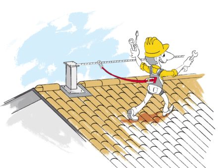 Operatore che cammina su un tetto in tegole collegato ad una linea vita